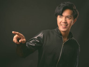 Genç yakışıklı Asya adam siyah arka plan stüdyo çekim