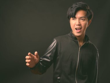 Genç yakışıklı Asya adam siyah arka plan stüdyo çekim