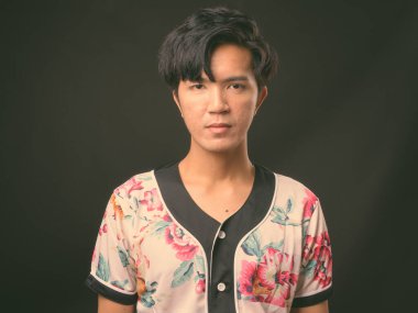 Genç yakışıklı Asya adam siyah arka plan stüdyo çekim