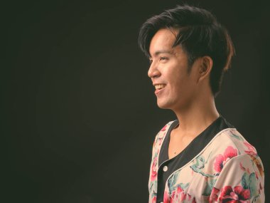 Genç yakışıklı Asya adam siyah arka plan stüdyo çekim