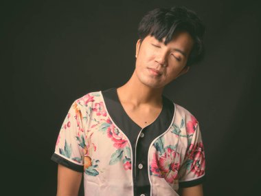 Genç yakışıklı Asya adam siyah arka plan stüdyo çekim