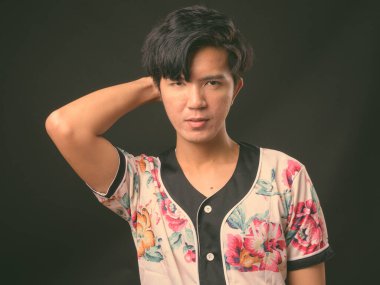 Genç yakışıklı Asya adam siyah arka plan stüdyo çekim