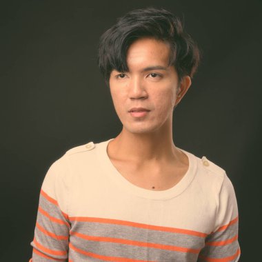 Genç yakışıklı Asya adam siyah arka plan stüdyo çekim