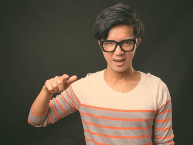 Genç yakışıklı Asya adam siyah arka plan stüdyo çekim