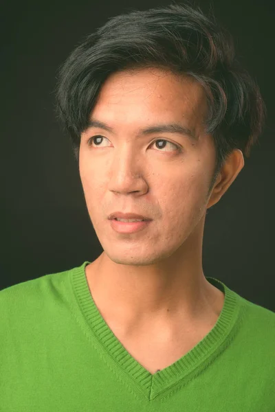 Mladý pohledný muž asijské černém pozadí — Stock fotografie