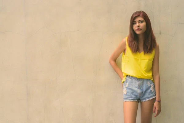Hermosa chica adolescente con vibrante camisa amarilla contra el fondo gris al aire libre —  Fotos de Stock