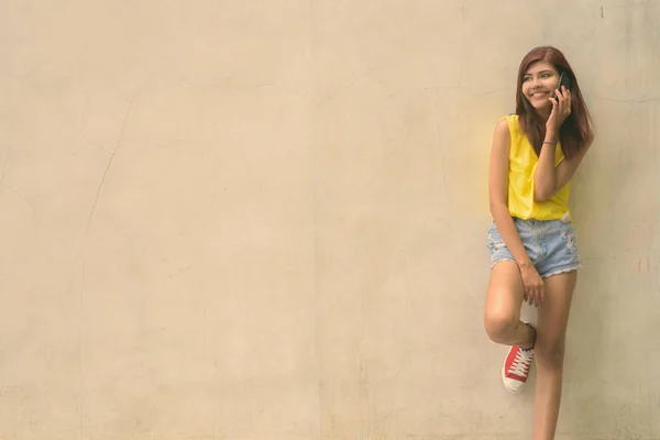 Szép kamasz lány visel élénk sárga inget, szürke háttérrel szabadban — Stock Fotó