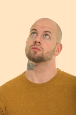 Beyaz arka planda izole edilmiş genç kaslı kel adamın stüdyo fotoğrafı.