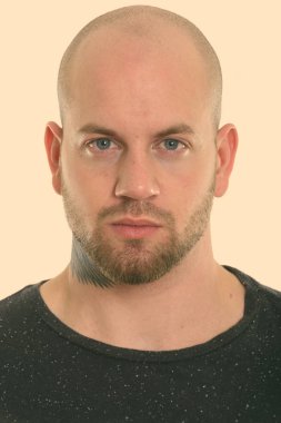 Beyaz arka planda izole edilmiş genç kaslı kel adamın stüdyo fotoğrafı.