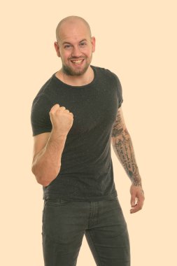 Beyaz arka planda izole edilmiş genç kaslı kel adamın stüdyo fotoğrafı.