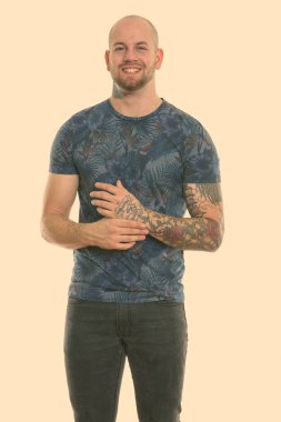 Beyaz arka planda izole edilmiş genç kaslı kel adamın stüdyo fotoğrafı.