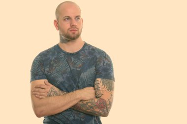 Beyaz arka planda izole edilmiş genç kaslı kel adamın stüdyo fotoğrafı.