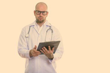 Beyaz arka planda izole edilmiş genç kaslı kel adamın stüdyo fotoğrafı.