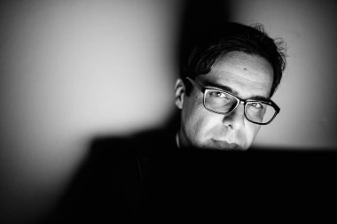 Studio shot of handsome Persian businessman against gray background in black and white