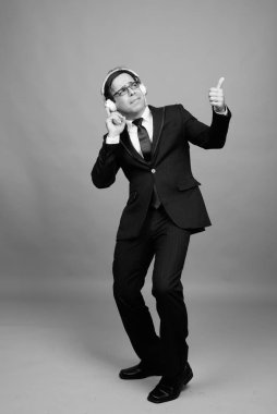 Studio shot of handsome Persian businessman against gray background in black and white
