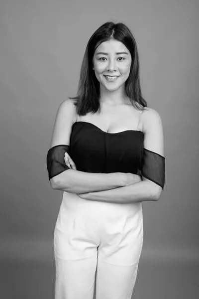 Giovane bella donna asiatica contro sfondo grigio — Foto Stock