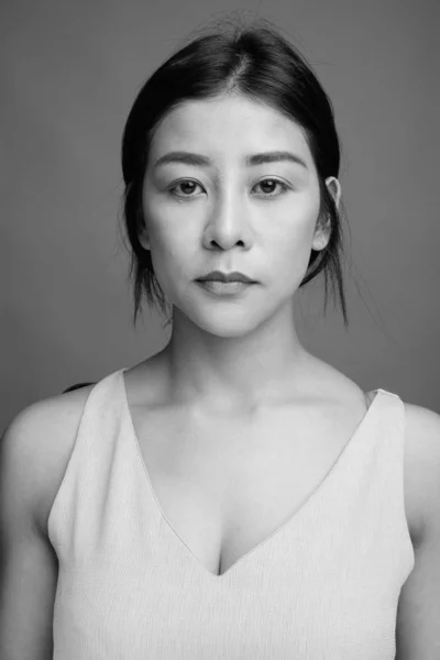 회색 배경 젊은 아름 다운 아시아 여자 — 스톡 사진