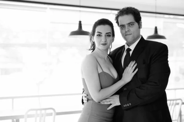 Iranian couple relaxing together at home in black and white