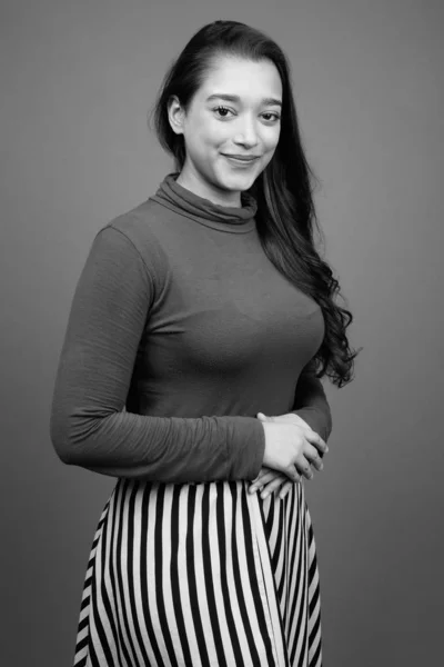 Young beautiful Indian woman against gray background — Stock Photo, Image