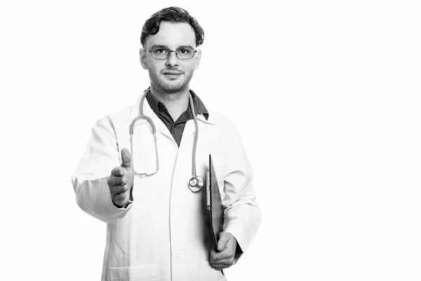 Studio záběr mladého muže lékaře drží schránka zároveň dává handshake — Stock fotografie