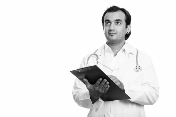 Studioaufnahme eines persischen Arztes, der beim Denken Klemmbrett hält — Stockfoto