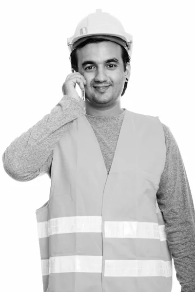 Feliz hombre persa trabajador de la construcción sonriendo mientras habla por teléfono móvil —  Fotos de Stock