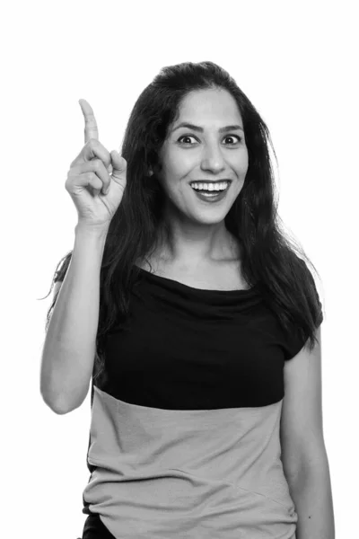 Estúdio tiro de mulher feliz persa sorrindo enquanto apontando o dedo para cima — Fotografia de Stock