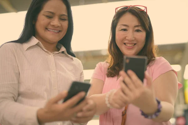 Dos mujeres asiáticas maduras juntas en la estación de skytrain en Bangkok, Tailandia — Foto de Stock