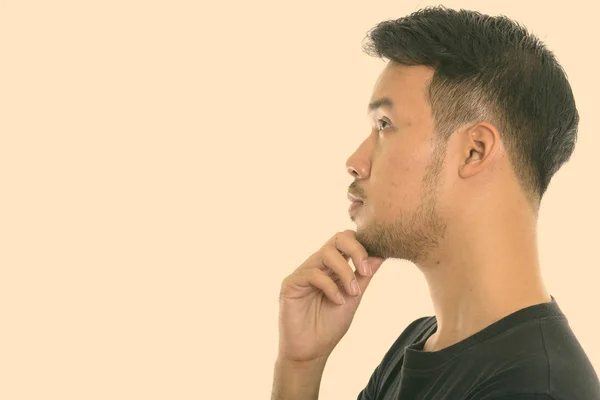 Perfil vista de joven asiático hombre pensando mientras mira hacia arriba —  Fotos de Stock