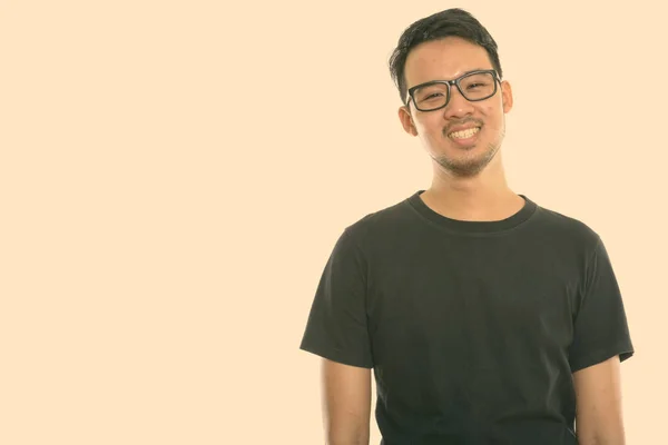 演播室拍摄的年轻快乐的亚洲男人戴着眼镜微笑的照片 — 图库照片