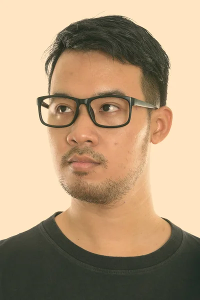 먼 곳을 바라보면서 안경을 쓰고 생각하는 젊은 아시아 남자의 얼굴 — 스톡 사진