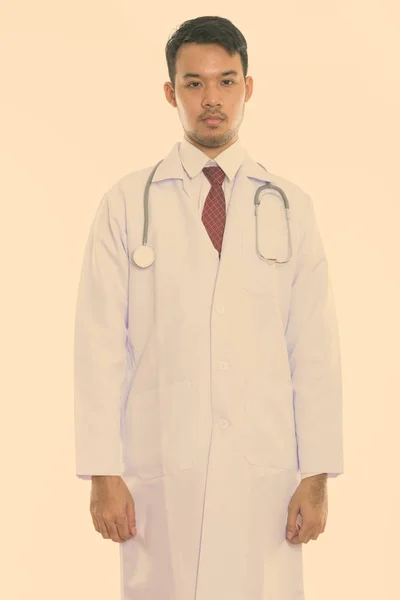 Studio skott av ung asiatisk man läkare står — Stockfoto