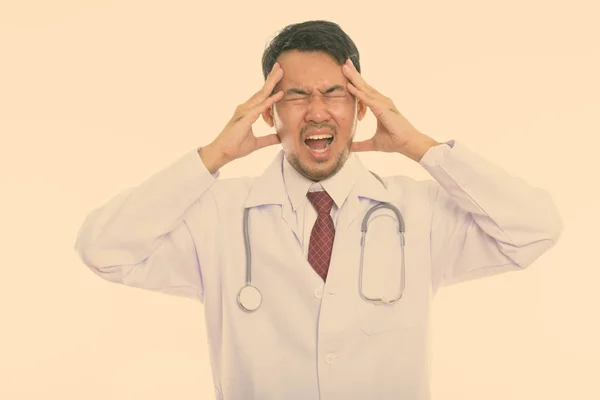 Studio shot van gestresste Aziatische jongeman arts hebben van hoofdpijn — Stockfoto