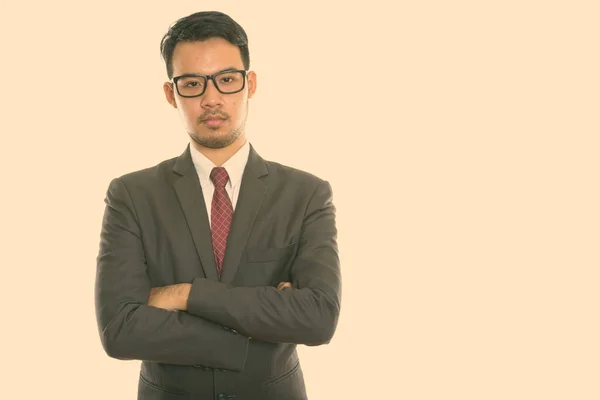 Estudio de disparo de joven empresario asiático con gafas con los brazos cruzados — Foto de Stock