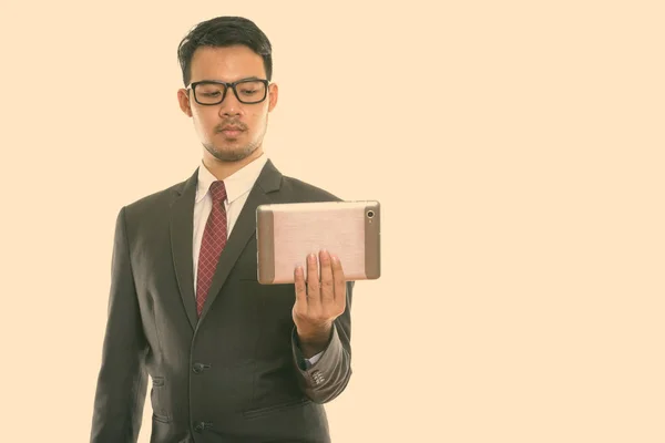 Studioaufnahme eines jungen asiatischen Geschäftsmannes mit digitalem Tablet — Stockfoto