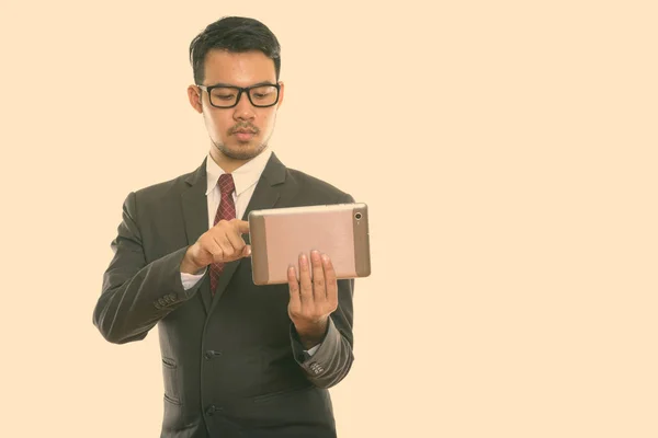 Estúdio tiro de jovem empresário asiático usando tablet digital — Fotografia de Stock