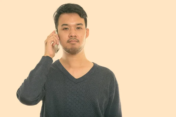 Foto studio pemuda Asia yang berbicara di telepon genggam — Stok Foto