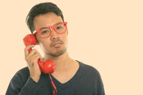 Крупным планом молодой азиат разговаривает по старому телефону — стоковое фото