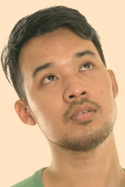 Face of young Asian man thinking while looking up — Stock Photo, Image