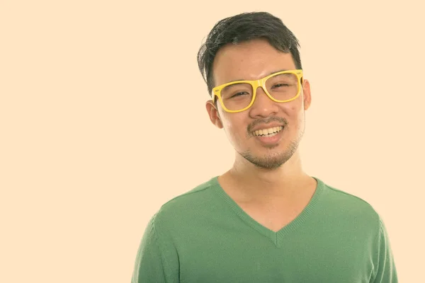 Studio záběr mladý šťastný asijské muž s úsměvem při nošení brýlí — Stock fotografie