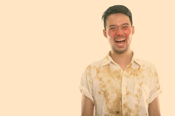 얼굴에 피를 머금고 웃는 행복 한 젊은 아시아 청년의 스튜디오 촬영 — 스톡 사진