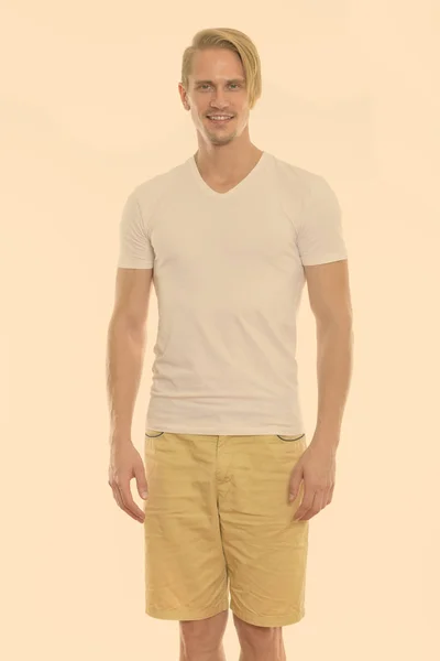 Studio shot of happy young handsome man smiling while standing — Stock Photo, Image