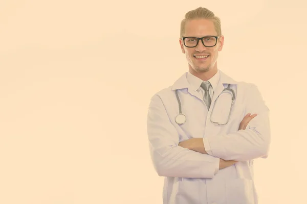 Studio shot of happy handsome man doctor smiling with arms crossed — Stok fotoğraf