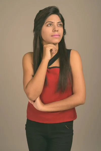 Retrato de jovem mulher indiana contra fundo cinza — Fotografia de Stock