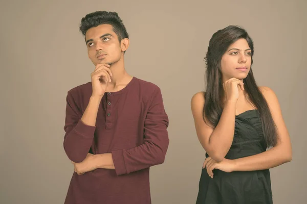 Young Indian man and young Indian woman together against gray background — 스톡 사진