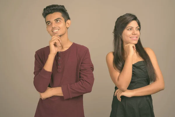 Young Indian man and young Indian woman together against gray background — 스톡 사진