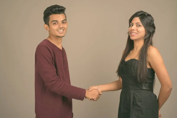 Young Indian man and young Indian woman together against gray background — 스톡 사진