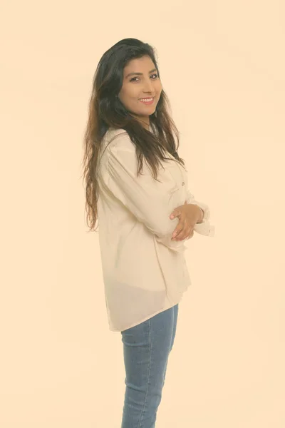 Studio colpo di giovane donna persiana felice sorridente e in piedi con le braccia incrociate isolato su sfondo bianco — Foto Stock