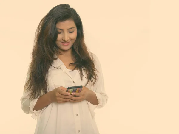 Studio colpo di giovane donna persiana felice sorridente durante l'utilizzo del telefono cellulare isolato su sfondo bianco — Foto Stock