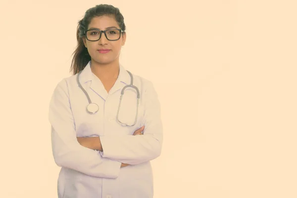 Studioaufnahme einer jungen schönen persischen Ärztin mit Brille und verschränkten Armen vor weißem Hintergrund — Stockfoto